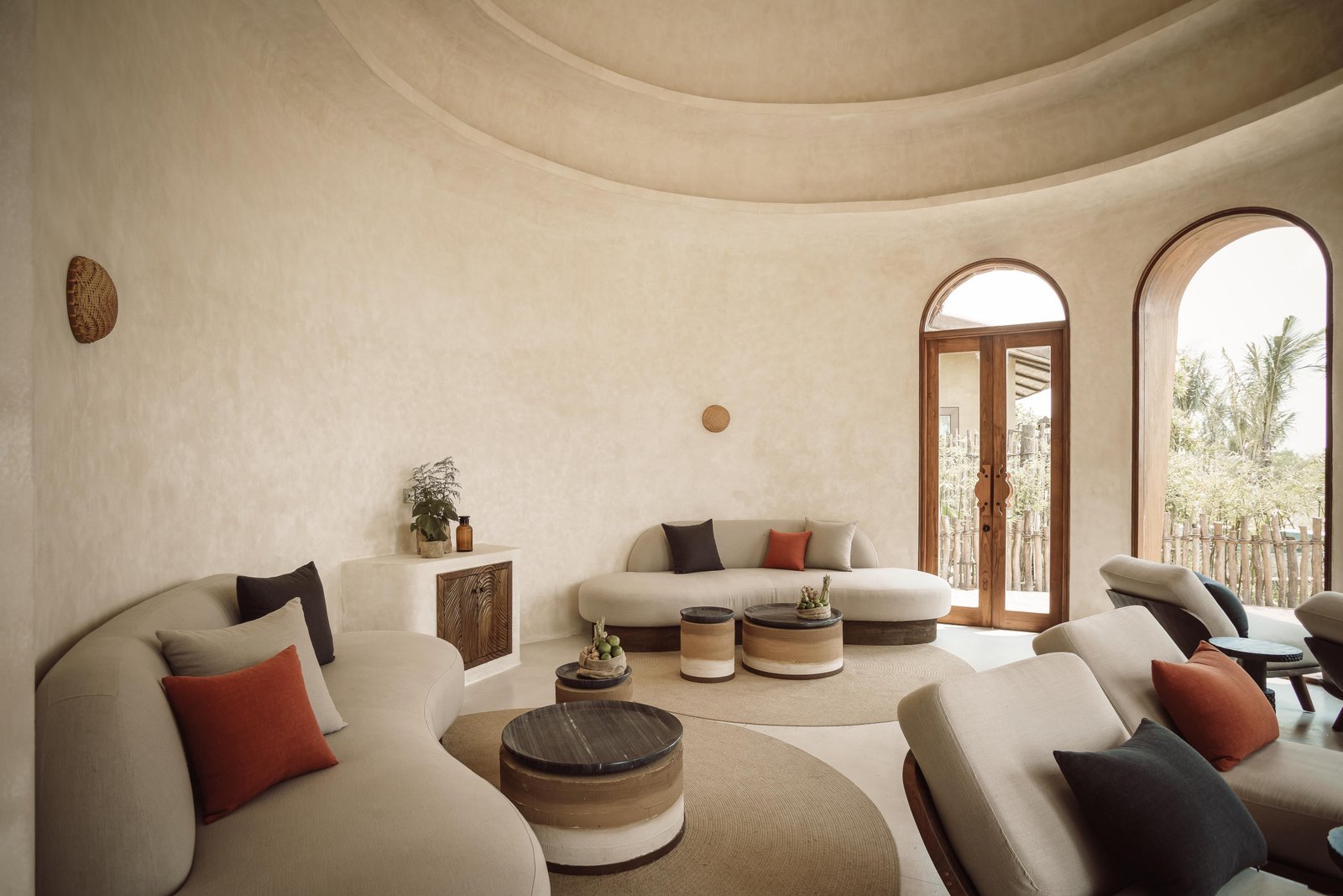 Domed lounge room with curved sofas and arched windows — intimate and considered